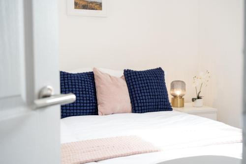 a bedroom with a white bed with blue pillows at Northern Hideaways, Castle View in Bellingham