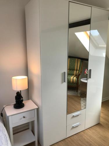 a large mirror in a bedroom with a lamp on a table at Appartement coquet dans maison individuelle in Lisses
