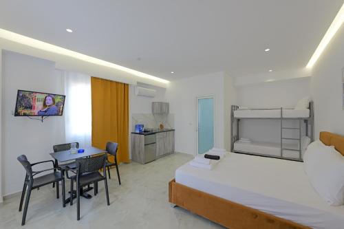 a bedroom with a bed and a table and chairs at Vila Sofia in Ksamil