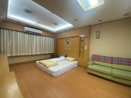 una habitación de hospital con una cama y un sofá en House 9, en Bangkok