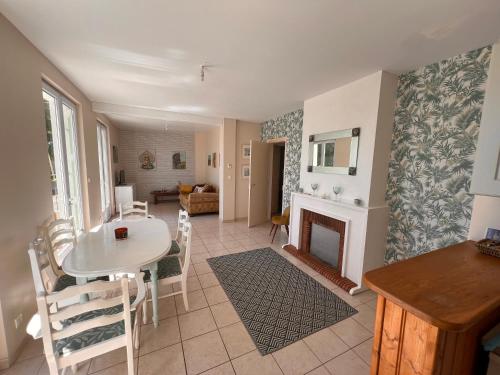 un salon avec une table et une cheminée dans l'établissement Charente 16 Mazerolles 2 bed, à Mazerolles
