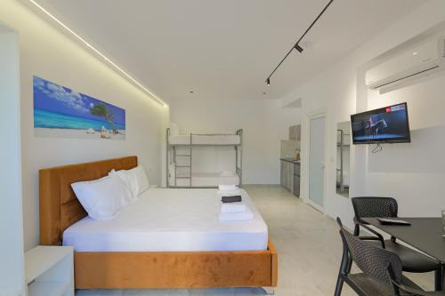 a bedroom with a bed and a desk and a television at Vila Sofia in Ksamil