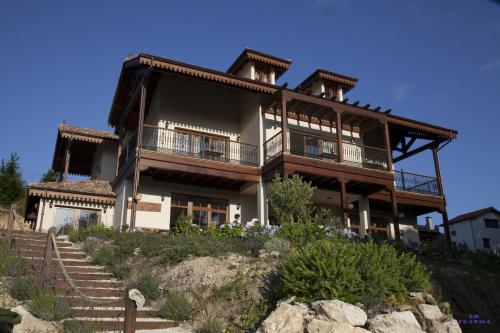 a large house on top of a hill with stairs at Hotel Rural Playa de Aguilar in Muros de Nalón