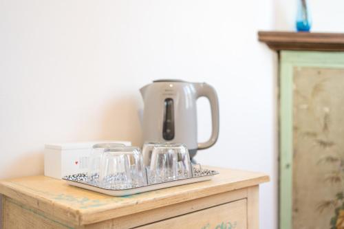 a mixer sitting on top of a wooden table with wine glasses at Art Rooms in Arezzo