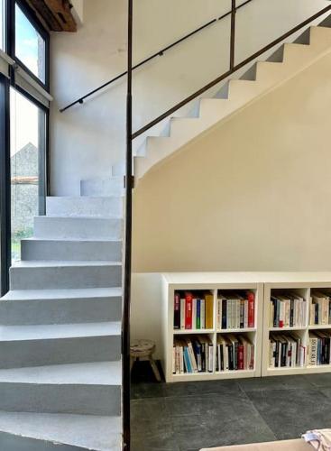 a staircase in a house with a book shelf at Stylish Country Loft one hour from Paris in Chevrainvilliers
