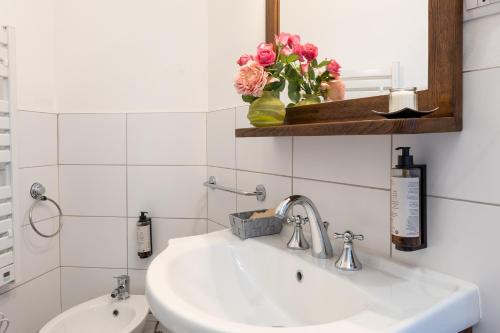 a bathroom with a sink and a mirror and flowers at Art Rooms in Arezzo