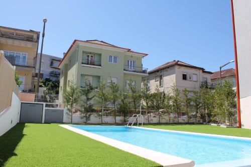 an apartment with a swimming pool in front of a building at StudentVille Academia in Coimbra