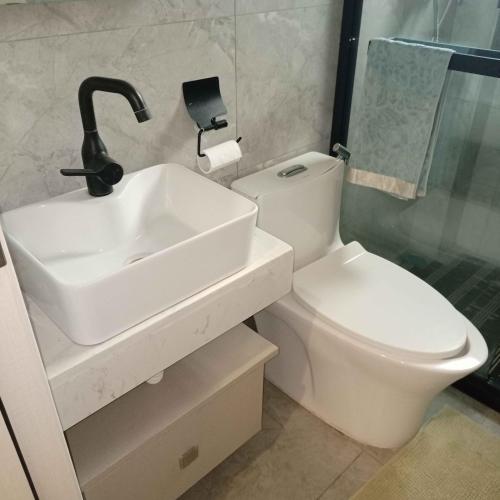 a white bathroom with a sink and a toilet at River sweet-conner in Nairobi