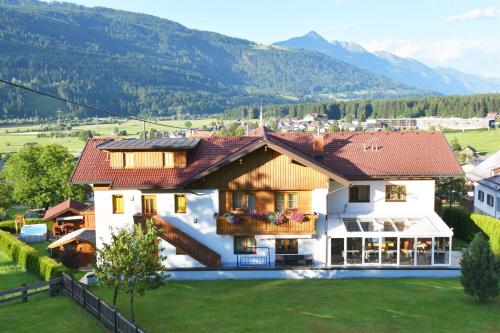 a house in a village with mountains in the background at Pension- Appartement Kristall in Tröpolach