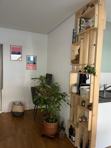 une pièce avec une étagère en bois et une plante dans l'établissement 2 chambres avec petit-déjeuner, à Pantin