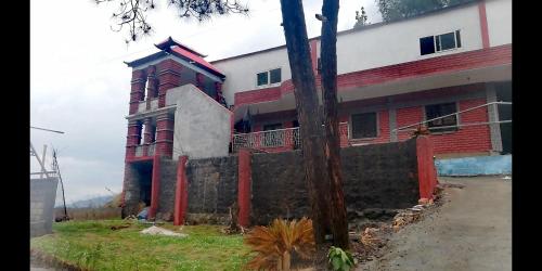 czerwono-biały budynek z płotem przed nim w obiekcie Luxury Sunset Villa w mieście Abbottabad