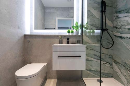 ein Bad mit einem WC, einem Waschbecken und einer Dusche in der Unterkunft Palm Tree House - Paris in Orpington
