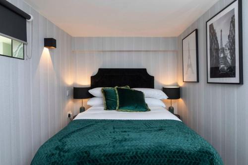 ein Schlafzimmer mit einem großen Bett und einer grünen Decke in der Unterkunft Palm Tree House - Paris in Orpington
