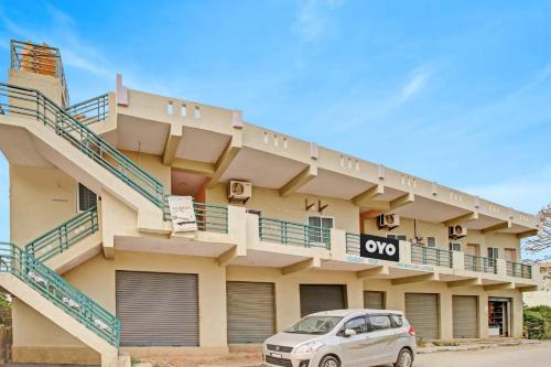 a white car parked in front of a building at Hotel O New Mayuri Lodge in Bāgepalli