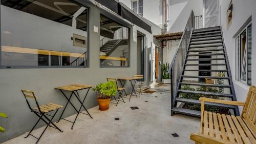 a patio with tables and chairs and a staircase at Hostellicious in Faro