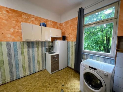 cocina pequeña con lavadora y ventana en Monteurwohnung - Worker's apartment - Pforzheim Belremstraße, en Pforzheim