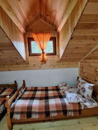 a bedroom with a bed and a window in a cabin at GAGO’S WOODEN HOUSE in Plav