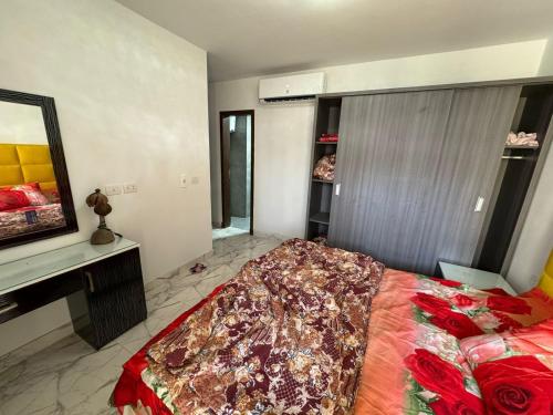 Un dormitorio con una cama grande y un espejo. en شالية للايجار فى بورتو, en `Ezbet Shalabi el-Rûdi