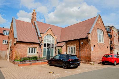 a brick building with a car parked in front of it at Guest Homes - The Old School House in Worcester