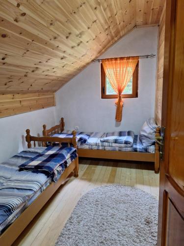 a bedroom with two beds and a window at GAGO’S WOODEN HOUSE in Plav