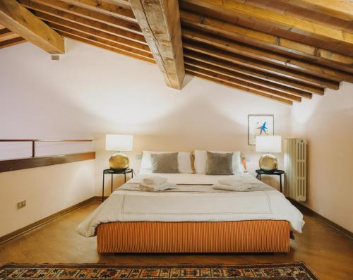 a bedroom with a large bed and wooden ceilings at Apartments Florence - Villa La Medicea with swimming pool in Montauto