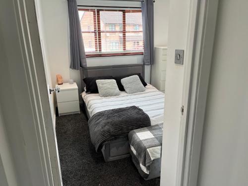 a small bedroom with a bed and a window at Chic & Modern Flat: Perfect for Exploring Kent! in Kent