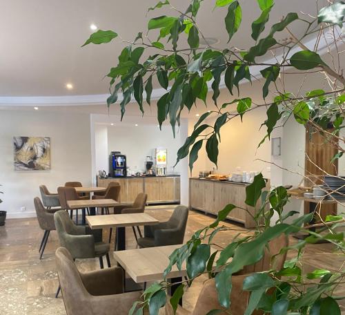 a restaurant with wooden tables and chairs and plants at Grand Hôtel De Calvi in Calvi