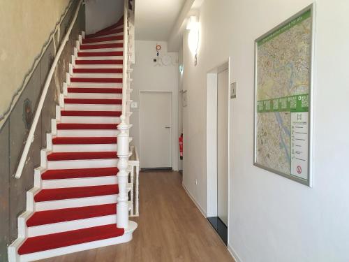 klatka schodowa z czerwono-białymi schodami w domu w obiekcie Aparthotel Sanni w Bremie
