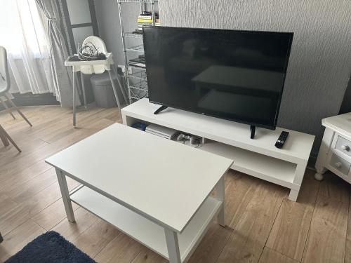 een woonkamer met een tv en een witte tafel bij A home away from home now with Netflix and PS4 in Blackpool