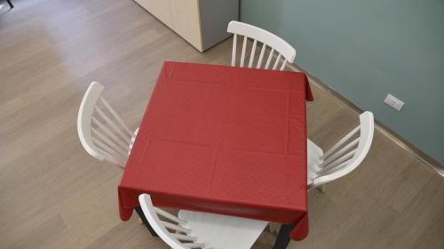a red table and two white chairs at a glass table at Loft Atenea in Agrigento
