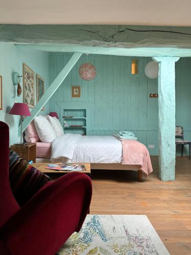 Un dormitorio con una cama, una silla y un sofá. en Sûn Chambres d'hôtes, en Rabastens