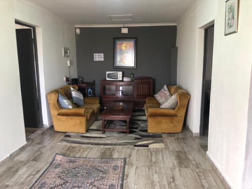 a living room with two chairs and a table at Rehoboth B&B in Bizana