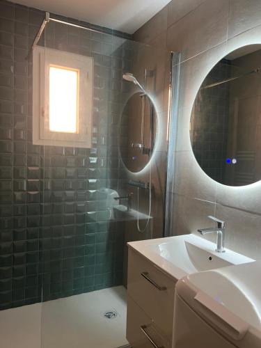 une salle de bain avec une douche, un lavabo et un miroir dans l'établissement Appartement vue mer et piscine, à Saint-Raphaël