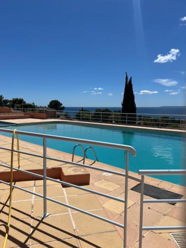une grande piscine entourée d'une balustrade en métal. dans l'établissement Appartement vue mer et piscine, à Saint-Raphaël