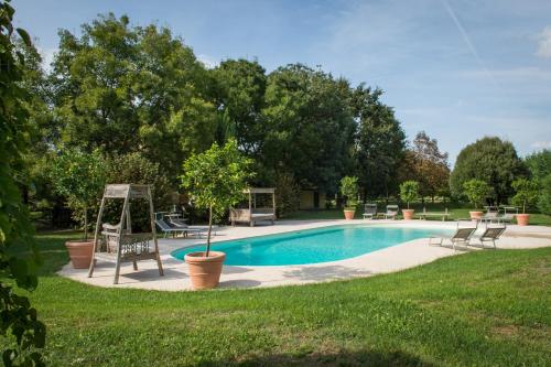 a swimming pool with chairs and a swing at Villa Cardinala - Ravenna in Gambellaro