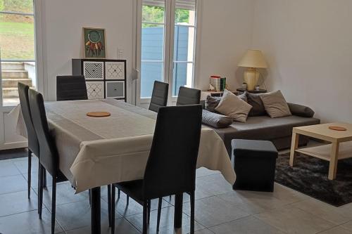 a living room with a table and a couch at Maison 6 personnes spacieuse proche Astérix in Pontpoint
