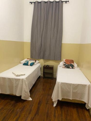 2 camas en una habitación con ventana en Hotel Central, en Araçatuba