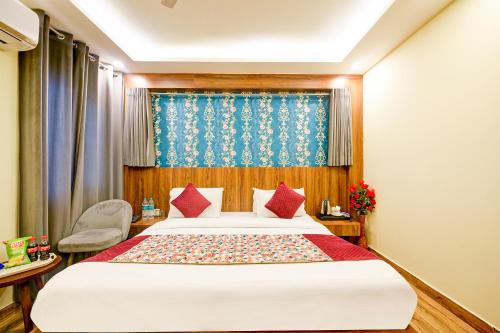 a bedroom with a large bed with red pillows at Wood Rose Hotel Near Delhi Airport in New Delhi