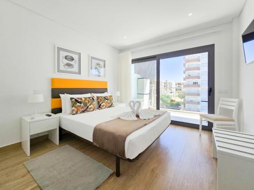 Un dormitorio con una cama grande y una ventana grande. en Apartment Praia Rocha Residence Jade, en Portimão