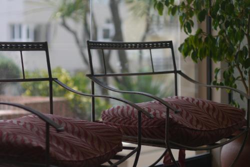 two chairs with red cushions sitting on a balcony at Club Sol Mar Del Plata in Mar del Plata
