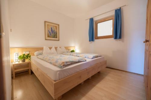 a bedroom with a bed with blue curtains and a window at Schlossblick in Vols am Schlern