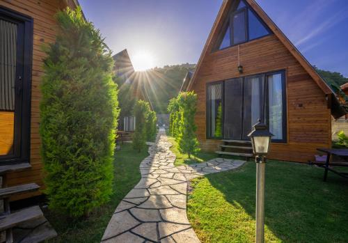 a house with a stone path next to a house at Karaöz Sapphire Bungalows in Kumluca