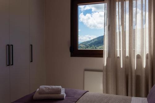 een slaapkamer met een raam en een handdoek op een bed bij Koukounaraki Apartment 1 in Skiathos-stad