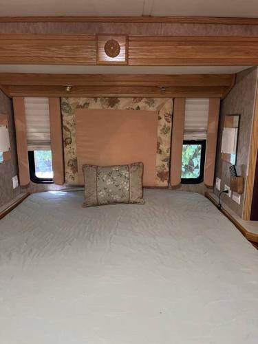 1 cama grande en la parte trasera de una caravana en STAY IN VIEQUES FOR LESS RV ONE BED STUDIO APARTMENT - KITCHEN - DINING - PRIVATE BATh - NOT FOR DRIVING, en Vieques