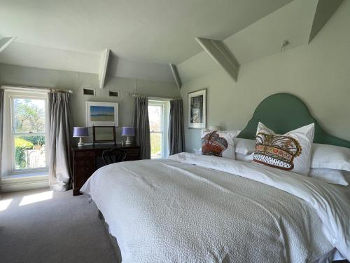 een slaapkamer met een groot bed met witte lakens en kussens bij Trewardale in Bodmin
