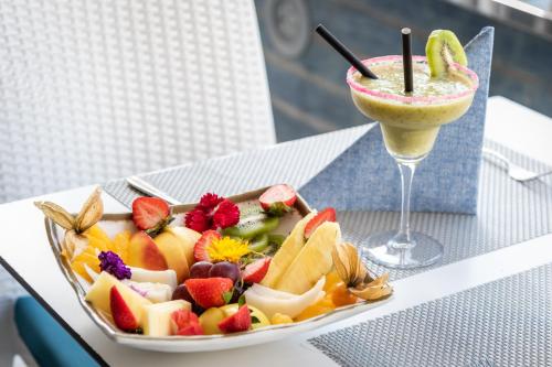 a plate of fruit and a drink on a table at Apartamentos Vistasol in Magaluf