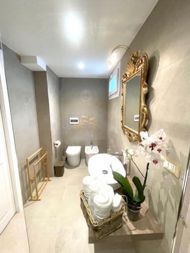 a bathroom with a toilet and a sink and a mirror at Dimora dei lidi in Fontane Bianche