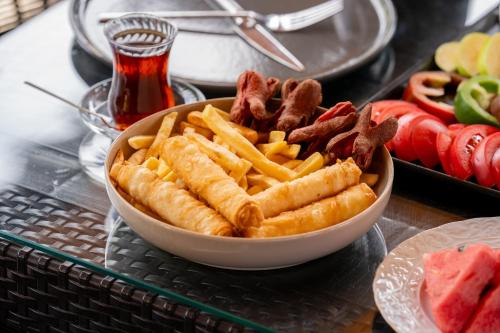 a bowl of food with bacon and french fries at Karaöz Sapphire Bungalows in Kumluca