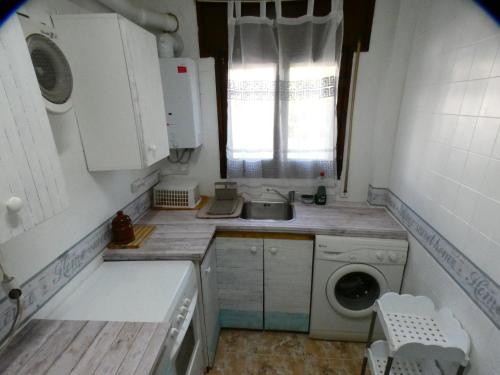 una pequeña cocina con fregadero y lavadora en Apartamento Tiebas, Cambrils, en Cambrils