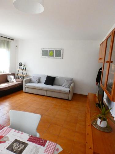 sala de estar con sofá blanco y suelo de madera en Apartamento Tiebas, Cambrils, en Cambrils